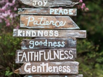 Weathered wooden signs spell out virtues: Love, Joy, Peace, Patience, Kindness, Goodness, Faithfulness, Gentleness, Self-Control.